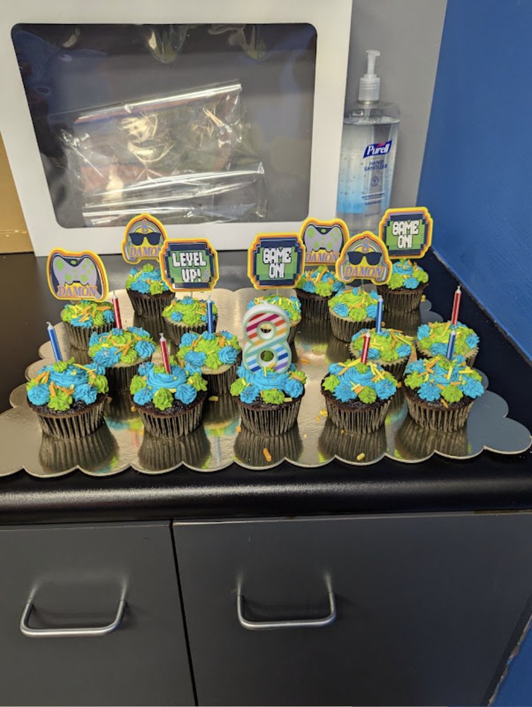 Video Gamer cupcake toppers with the name DAMON and a big number 8 on a tray of cupcakes